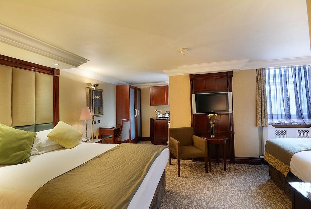 Montcalm Chilworth Townhouse, Paddington Hotell London Eksteriør bilde The photo shows a hotel room featuring a well-furnished space with two beds. One bed has white sheets with a brown bedspread, and there are decorative pillows. The room includes ambient lighting and a window with curtains. There is a small sitting ar