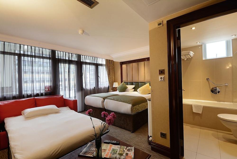 Montcalm Chilworth Townhouse, Paddington Hotell London Eksteriør bilde The photo shows a hotel room that features a modern design. On one side, there is a bed with a white duvet and a mattress placed directly on the floor, while on the other side, there are two beds with green and white bedding. The room has large windo