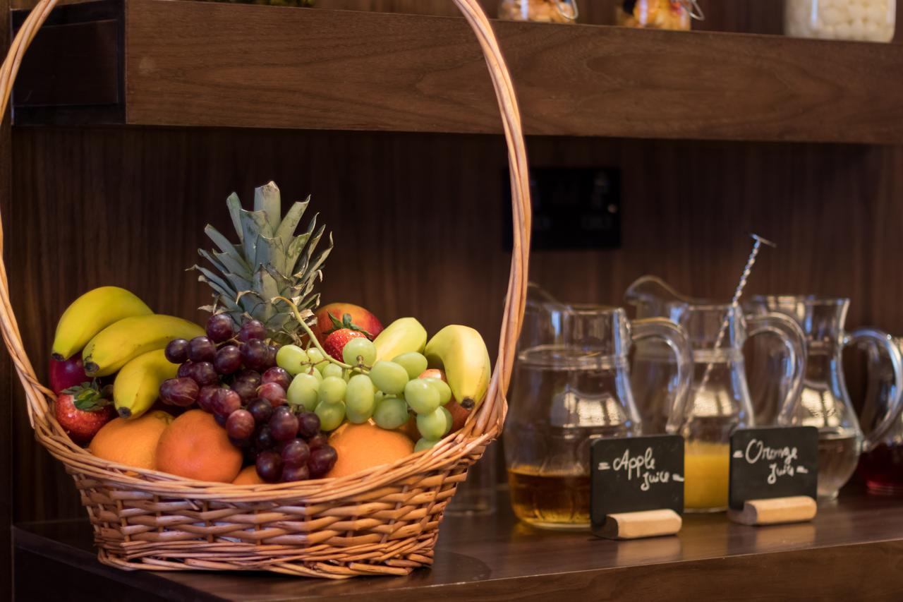 Montcalm Chilworth Townhouse, Paddington Hotell London Eksteriør bilde The photo shows a wicker basket filled with a variety of fruits, including bananas, oranges, grapes, and a pineapple. In the background, there are several glass pitchers and chalkboard signs that indicate "apple juice" and "orange juice." The setting