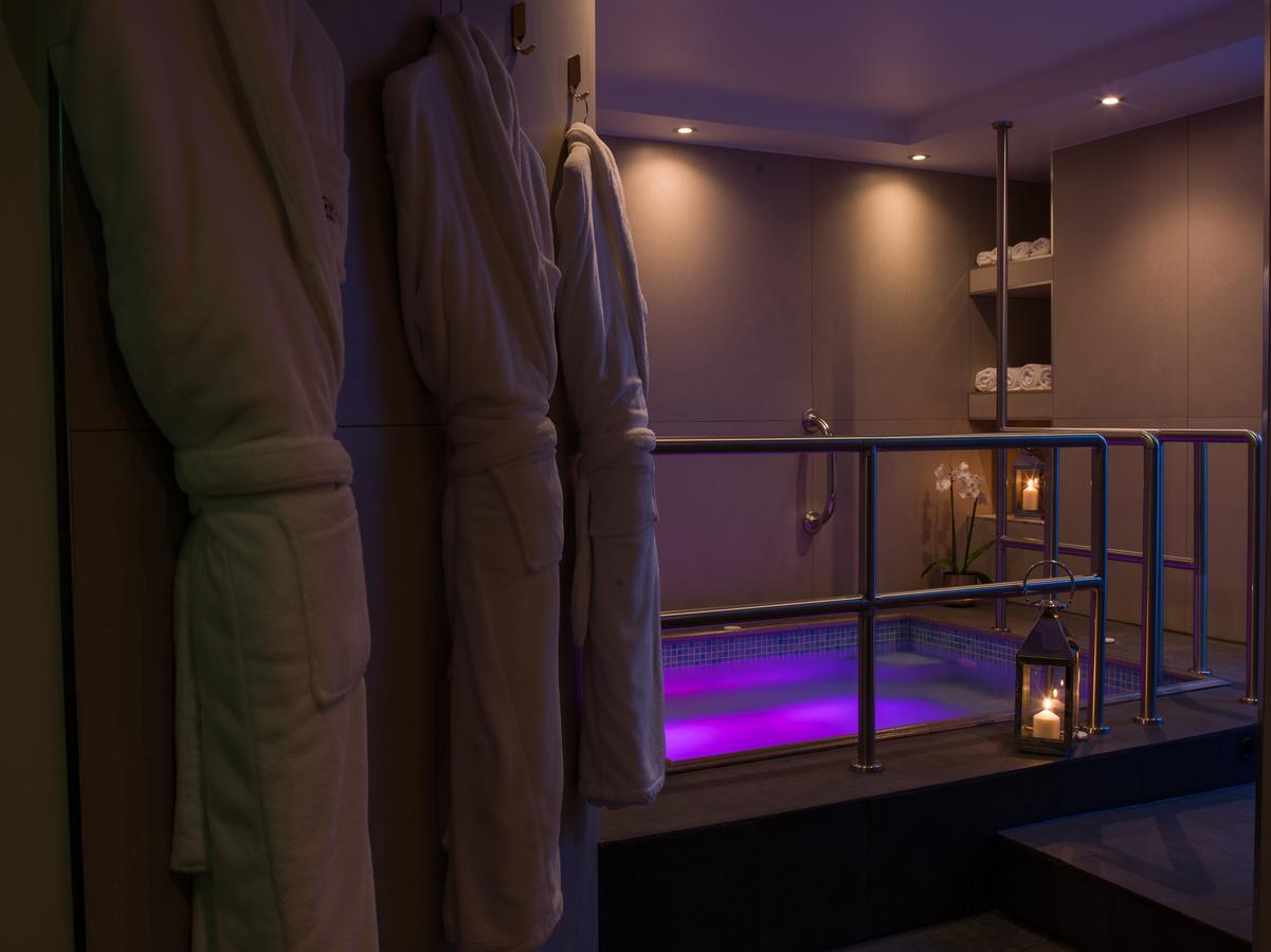 Montcalm Chilworth Townhouse, Paddington Hotell London Eksteriør bilde The photo depicts a serene spa setting. On one side, there are several plush bathrobes hanging on a rail, suggesting a relaxing atmosphere. In the background, a hot tub is visible, illuminated with soft purple lighting, enhancing the tranquil vibe. T