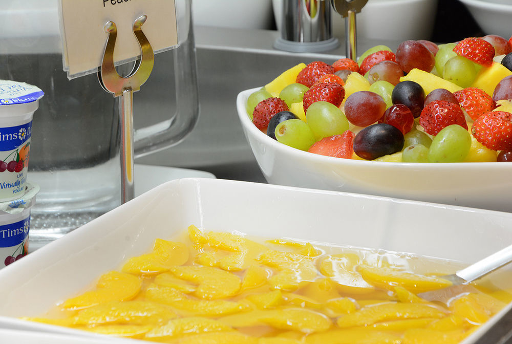 Montcalm Chilworth Townhouse, Paddington Hotell London Eksteriør bilde The photo shows a spread of fresh fruit options. In the foreground, there is a dish containing sliced mango pieces in a light syrup. In the background, there's a bowl of mixed fruit that includes strawberries, green grapes, and purple grapes. There i