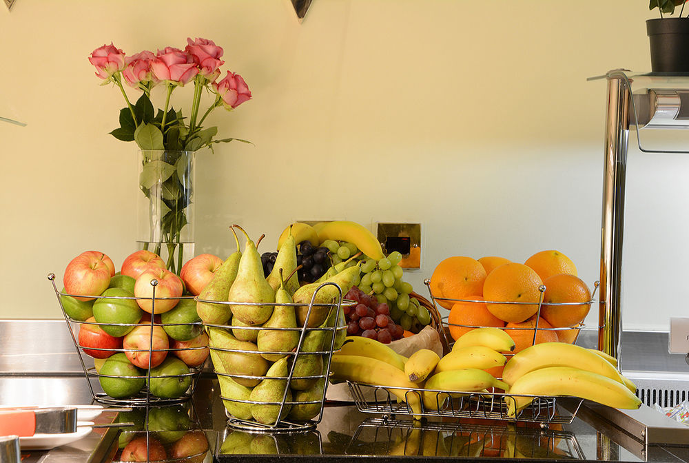 Montcalm Chilworth Townhouse, Paddington Hotell London Eksteriør bilde The photo shows a countertop arrangement with several baskets of fruit. There are green and red apples in one basket, green and yellow pears in another, and a mixture of grapes and bananas in different baskets. Additionally, there are oranges arrange