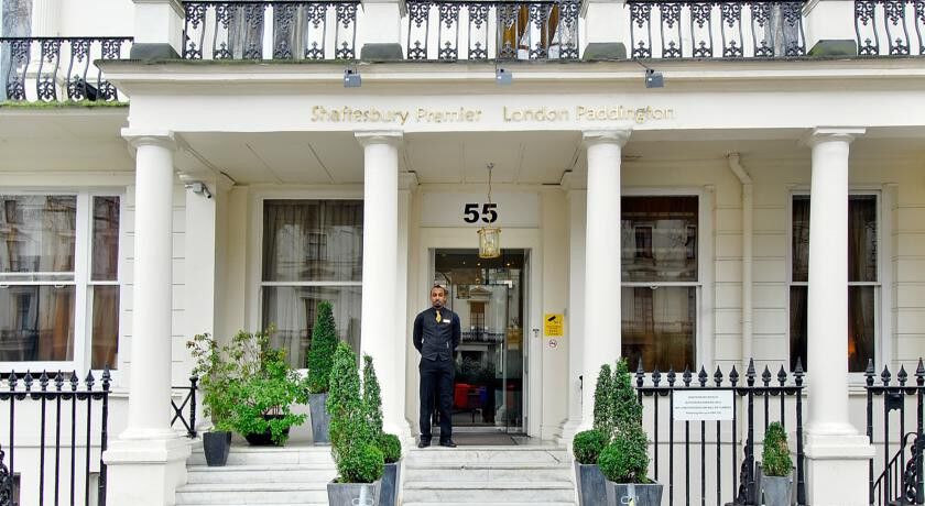 Montcalm Chilworth Townhouse, Paddington Hotell London Eksteriør bilde The photo shows the entrance of a building, specifically the front of a hotel or hospitality establishment named "St. Athansbury Premier London Paddington." The entrance features a set of columns and a number "55" displayed prominently. A person is s